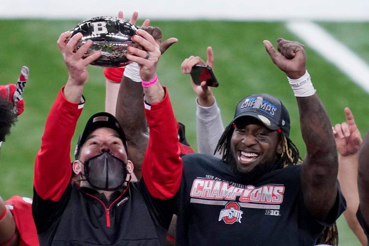 Ohio State head coach Ryan Day, left, holds the trophy along side running back Trey Sermon after defeating Northwestern in the Big Ten championship NCAA college football game, Saturday, Dec. 19, 2020, in Indianapolis. Ohio State won 22-10.
