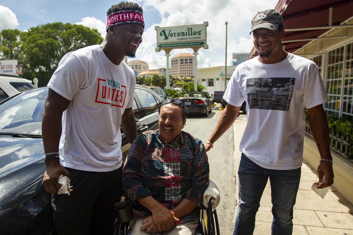 Miami Dolphins’ linebacker Jerome Baker (55), left, and safety Minkah Fitzpatrick (29), meet with Dr. Albert Cohen outside of Versailles in Little Havana during the team’s Football Unites: Cultural Tours event on Tuesday, September 18, 2018. The event unites Miami Dolphins players, alumni and staff with community leaders and law enforcement to experience the cultural diversity of South Florida.