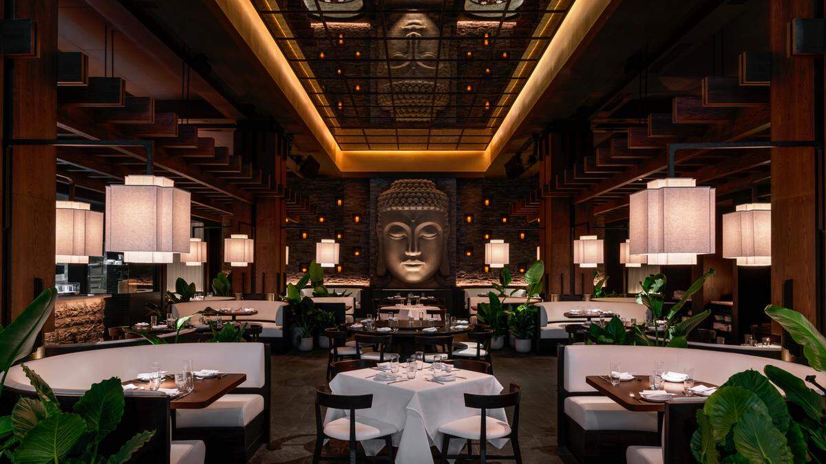 A stone Buddha overlooks the main indoor dining room at Toku in Aventura.