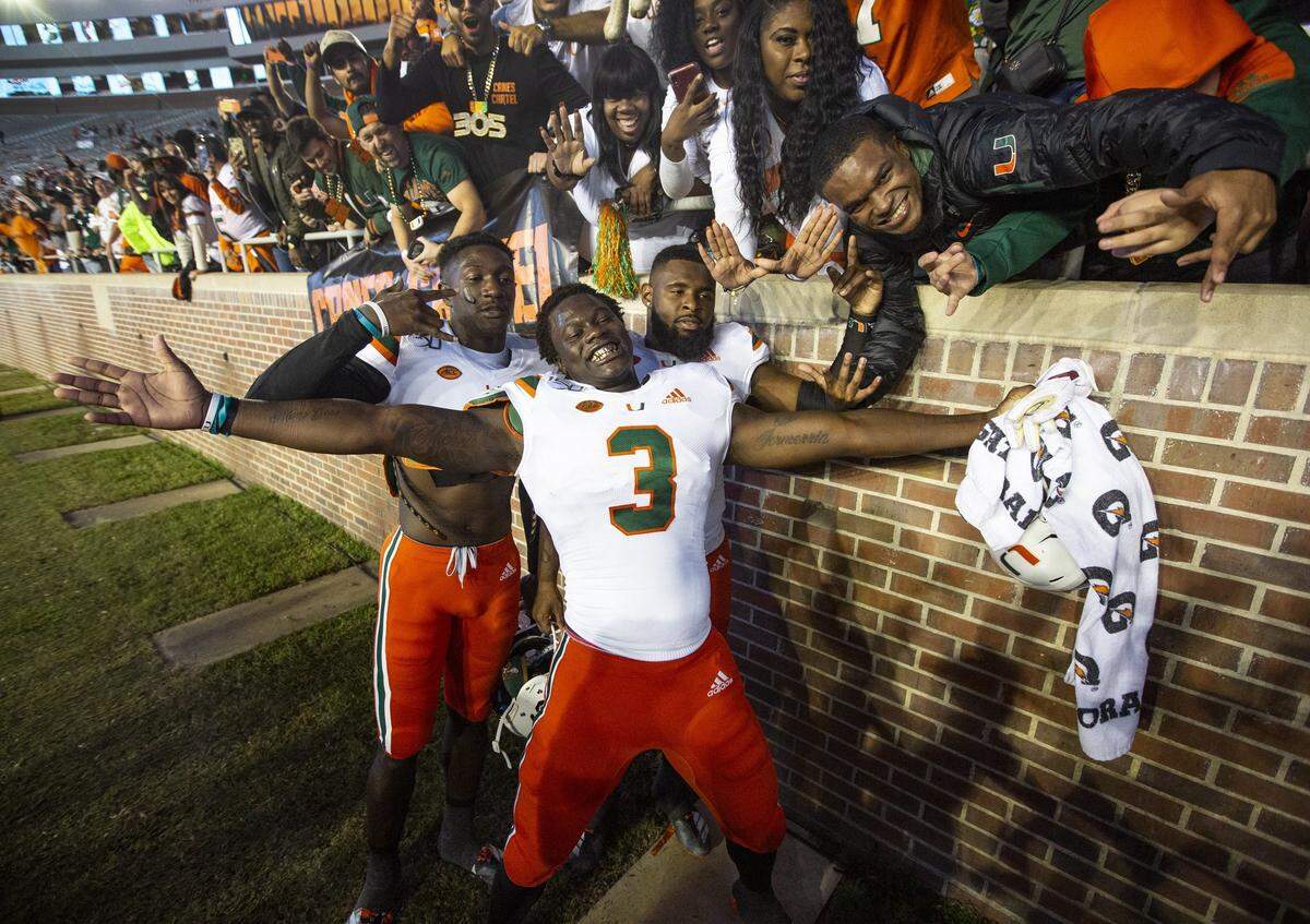 Miami Hurricanes striker Gilbert Frierson (3) and teammates celebrate with fans after the win over the Seminoles at Doak Campbell Stadium in Tallahassee on Saturday, November 2, 2019. 