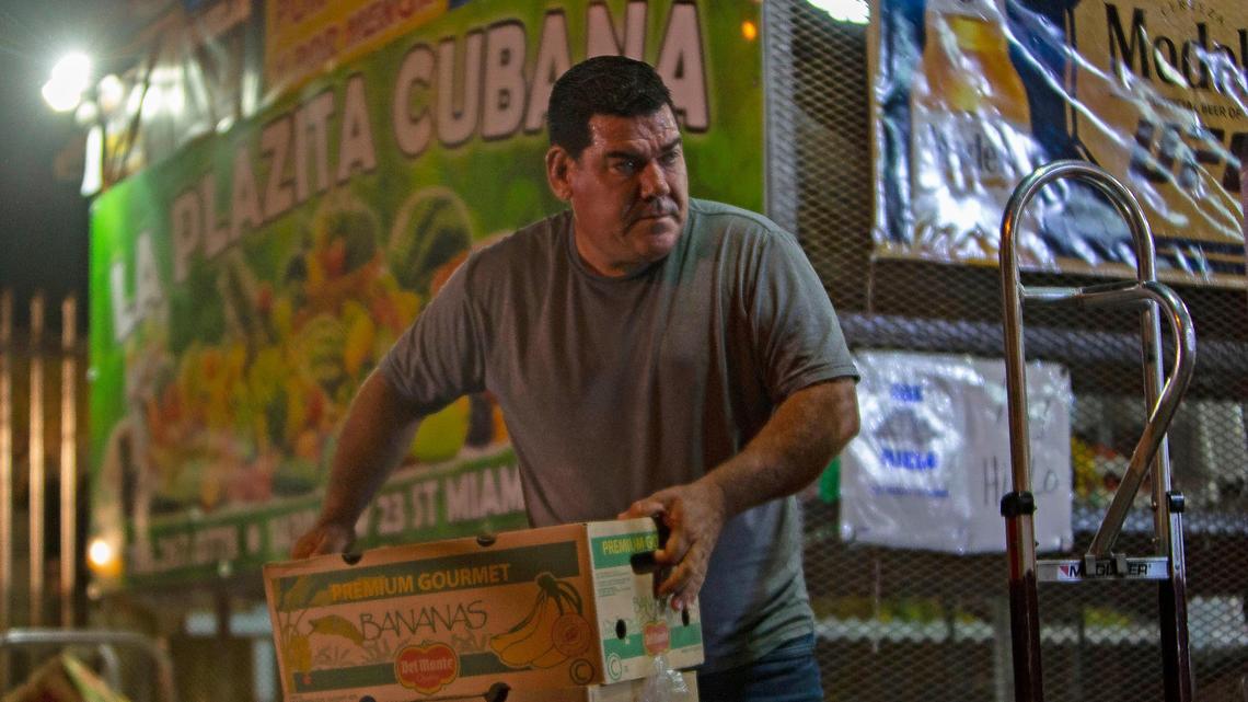 Arturo Tamayo sifts through produce at a market early in the morning before starting the day driving  his bodega truck through neighborhoods in Miami, FL, on Wednesday, June 20, 2018.