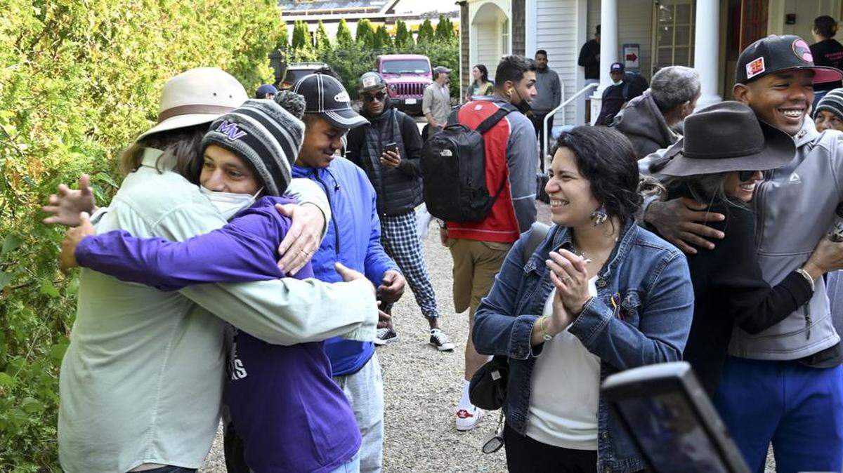 Carlos Munoz hugs Larkin Stallings, of Vineyard Haven, Massachusetts, as he and other immigrants prepare to leave Edgartown on Martha’s Vineyard.