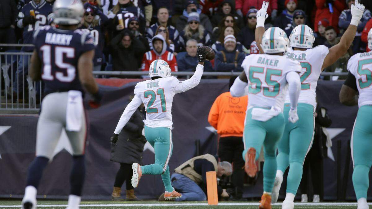 Miami Dolphins safety Eric Rowe runs back an interception for a touchdown in the first half of Sunday’s game against the Patriots, h