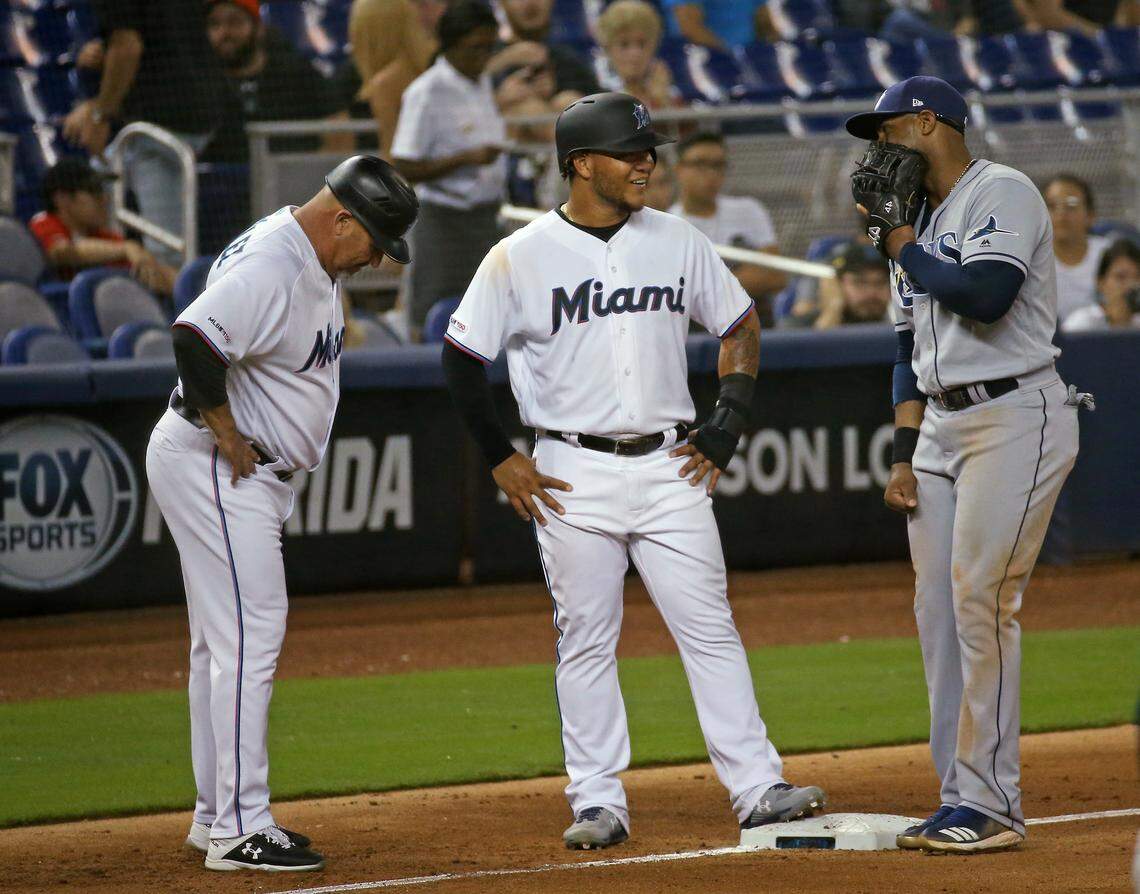 Miami Marlins left fielder Harold Ramirez (47) and third base coach Fredi Gonzalez (33) talk with Tampa Bay Rays third baseman Yandy Diaz (2) during the eighth inning of an interleague Major League Baseball game at Marlins Park in Miami, Tuesday, May 14, 2019.