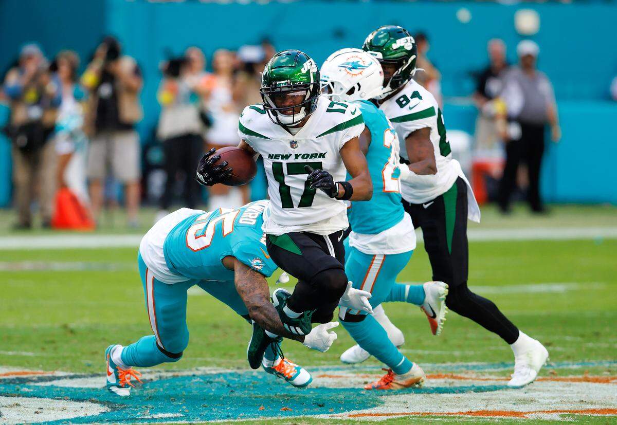 New York Jets wide receiver Garrett Wilson (17) is being tackled by Miami Dolphins cornerback Xavien Howard (25) during third quarter of an NFL football game at Hard Rock Stadium on Sunday, January 8, 2023 in Miami Gardens, Florida.