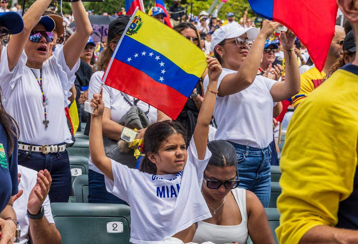 A little girl waves a Venezuelan flag.