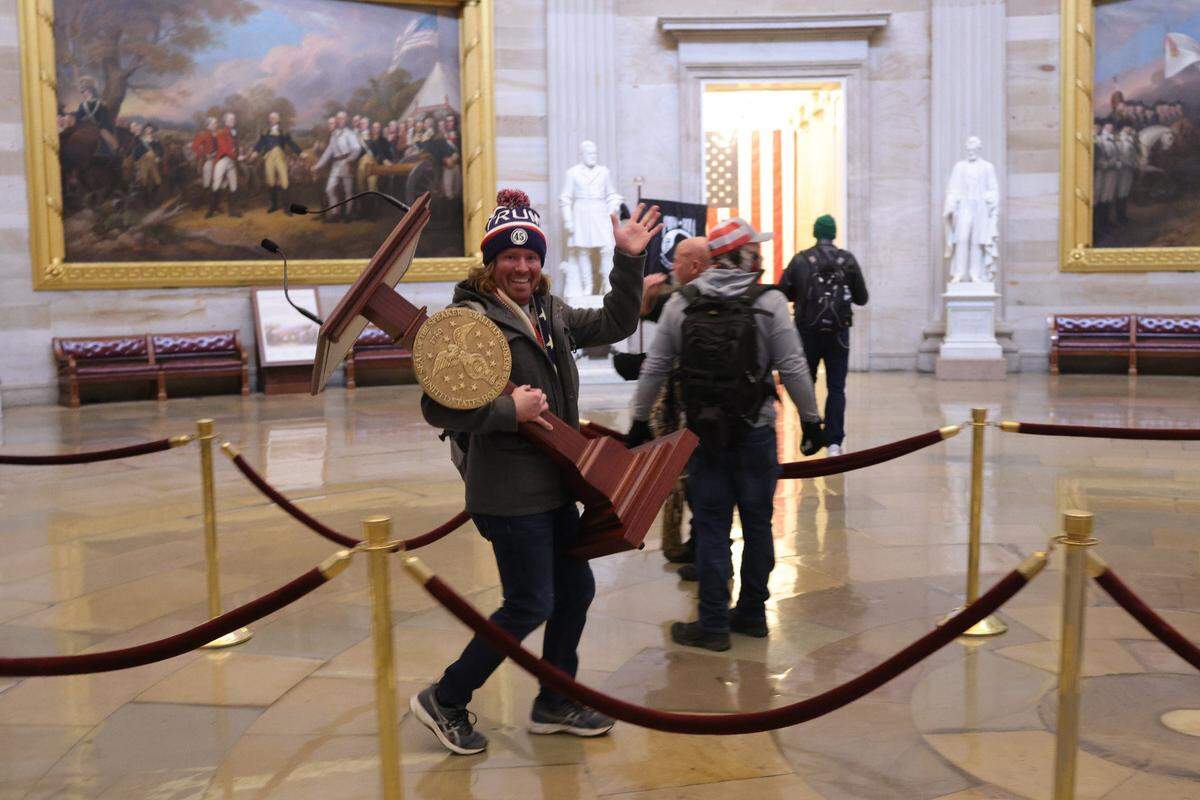 Adam Johnson, of Parrish, Florida, carries the lectern of U.S. Speaker of the House Nancy Pelosi through the Rotunda of the U.S. Capitol after a mob stormed the building on Jan. 6, 2021, in Washington, D.C.