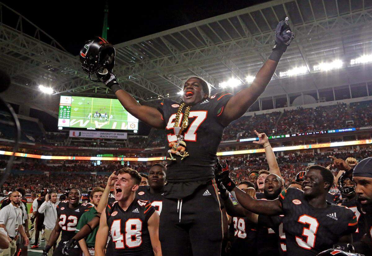 Miami Hurricanes defensive lineman Jonathan Garvin (97) celebrates with the turnover chain after scoring on a fumbled ball by North Carolina Tar Heels quarterback Nathan Elliott (11) in the first quarter as the University of Miami Hurricanes host the North Carolina Tar Heels at Hard Rock Stadium in Miami Gardens on Thursday, September 27, 2018.