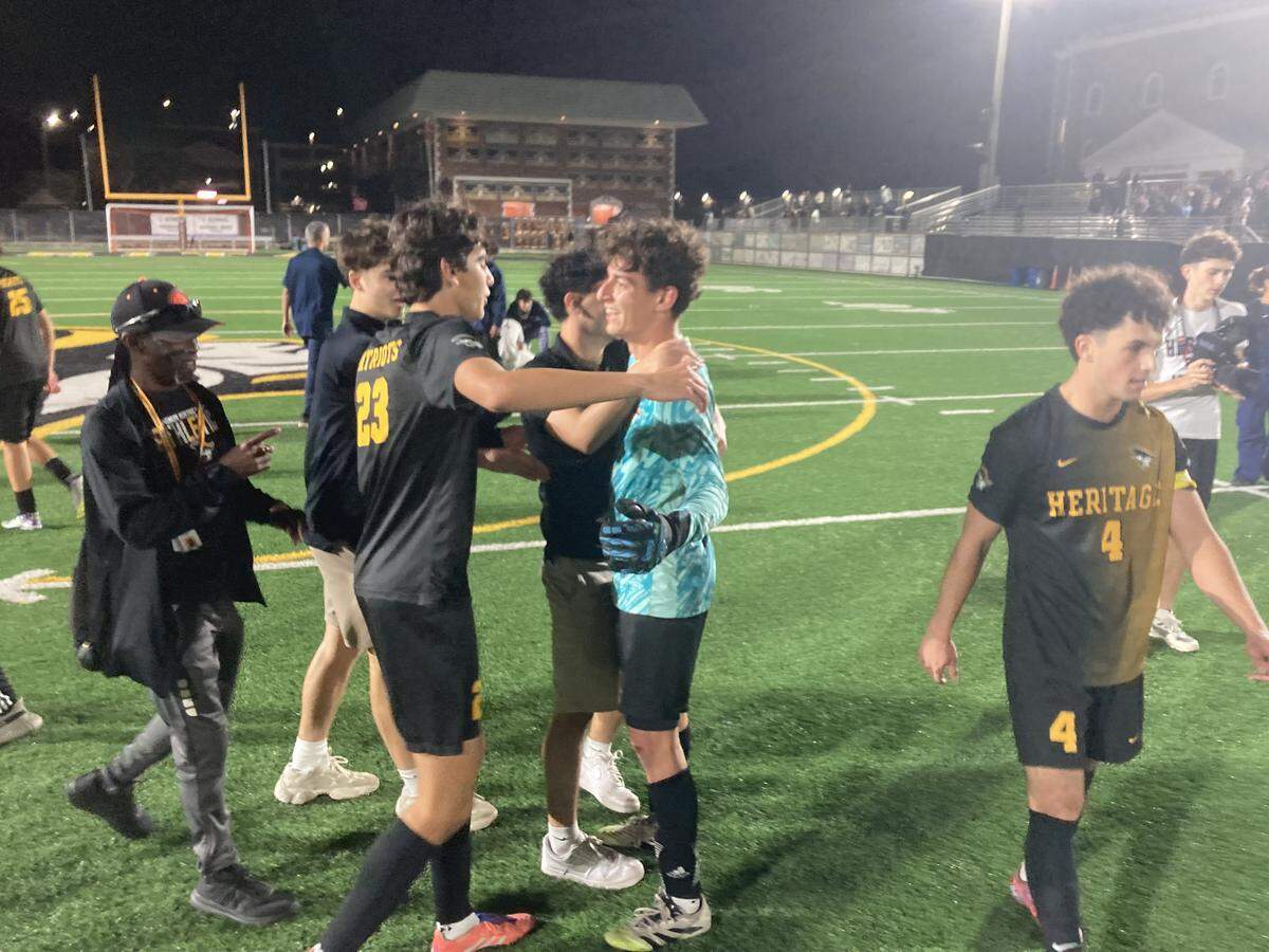 American Heritage goalkeeper Alex Vanhaeren (light blue jersey) is congratulated by teammates after making a game-clinching save in a penalty kick shootout win over Mater Lakes on Tuesday in the Region 4-4A boys’ soccer final at American Heritage in Plantation, Fla.