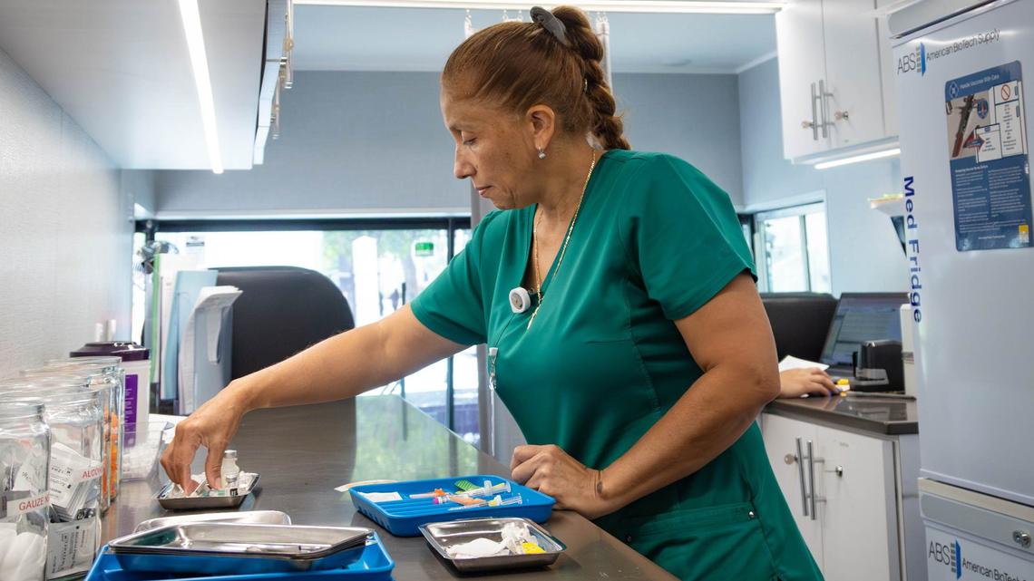 Pediatrician Karen Mendez prepares a vaccine inside the SHOTZ-2-GO mobile pediatric vaccination unit outside of the UHealth Jackson Metro Station, formerly known as the Civic Center, on Friday, July 12, 2024, in Miami.