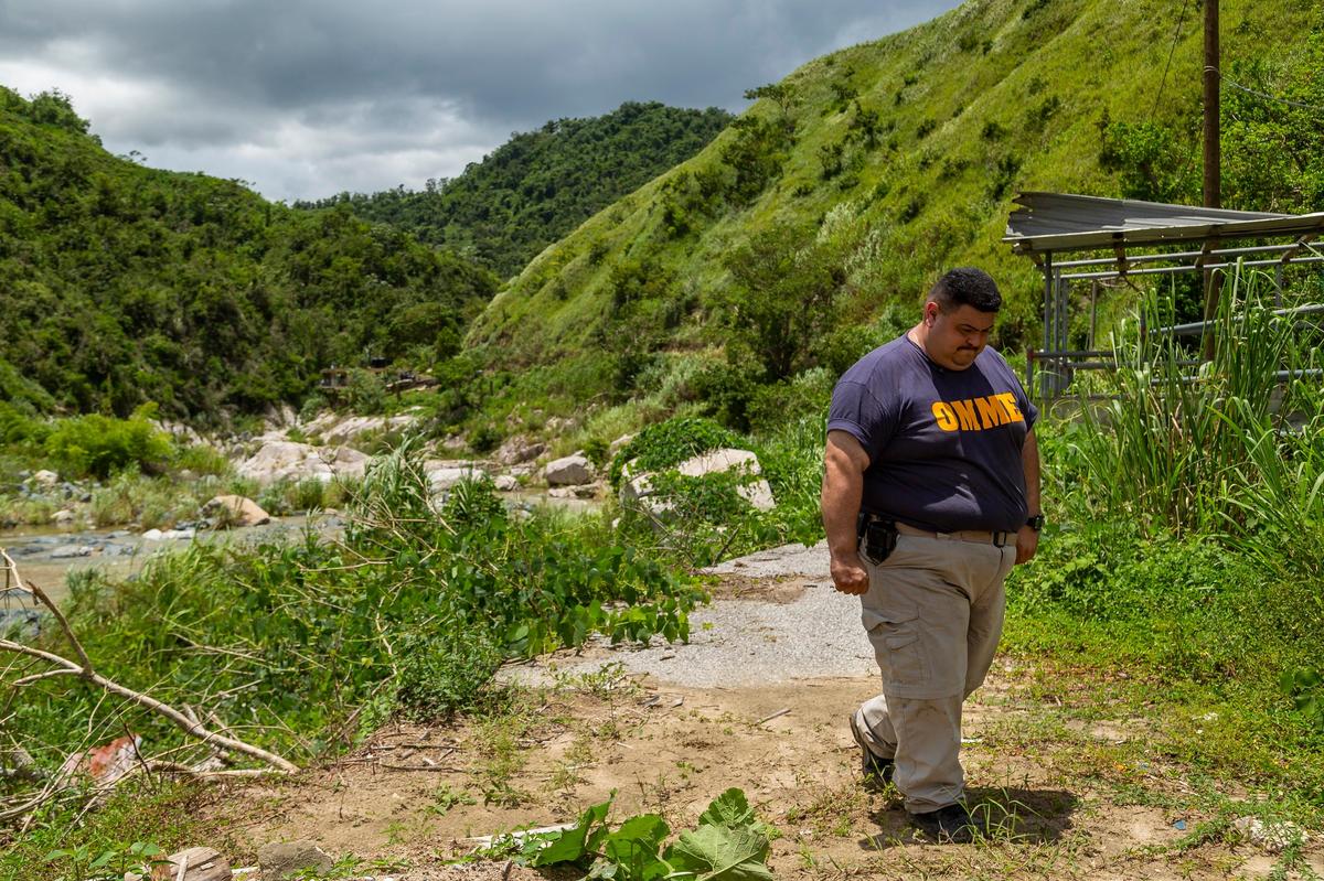 Héctor Cruz, director of the emergency management office in Utuado, Puerto Rico, walks past the remains of a collapsed bridge. Cruz said his town is still recovering a year after Hurricane Maria destroyed or damaged 20 bridges, washed roads and homes off the mountainside and cut power.