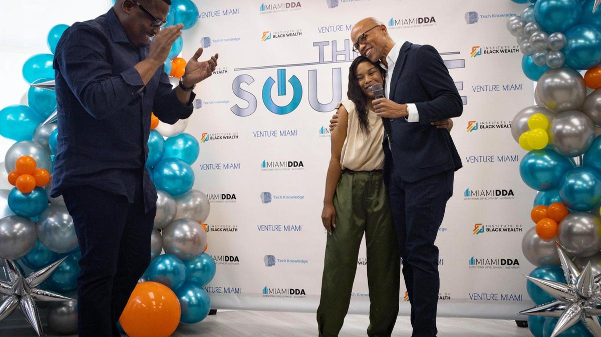 Desiray Malcolm, an account manager at Kaseya, center, hugs her mentor Hilmon Sorey, right, and Ted Lucas, co-founders of The Source, a Black-owned tech hub, on Thursday, Feb. 15, 2024, in downtown Miami.
