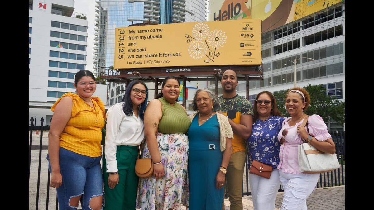 Luz Rossy and her family gather in front of the billboard with her winning Zip Ode poetry selected this year for its celebration of home.