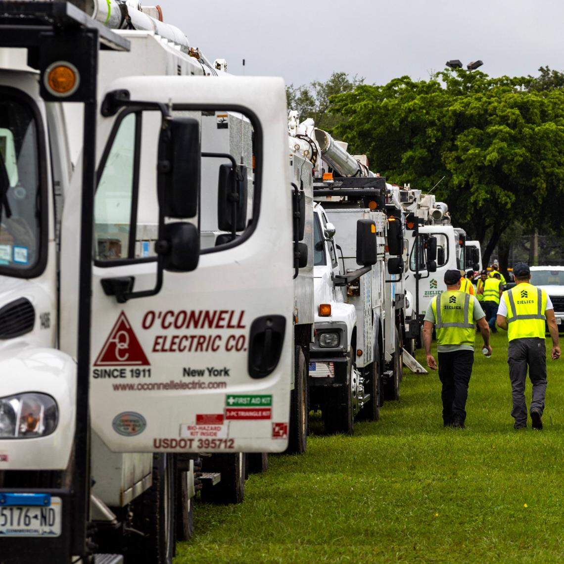 Electrical trucks sit parked at Tamiami Park as they wait on standby for the aftermath of Hurricane Milton on Tuesday, Oct. 8, 2024, in Miami.