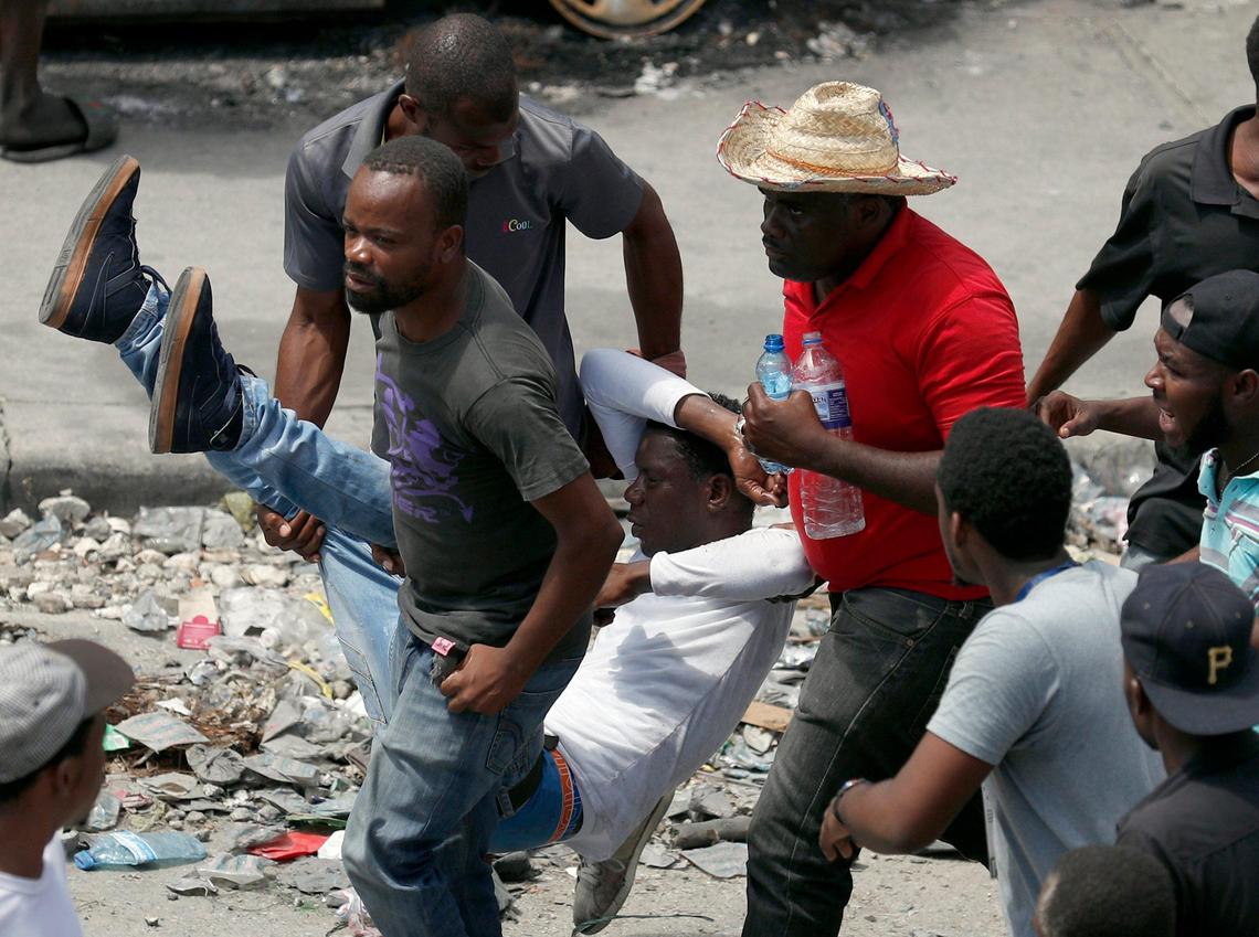 An injured demonstrator is carried to safety during a protest calling for the resignation of President Jovenel Moise, in Port-au-Prince, Haiti, Friday, Oct. 4, 2019.