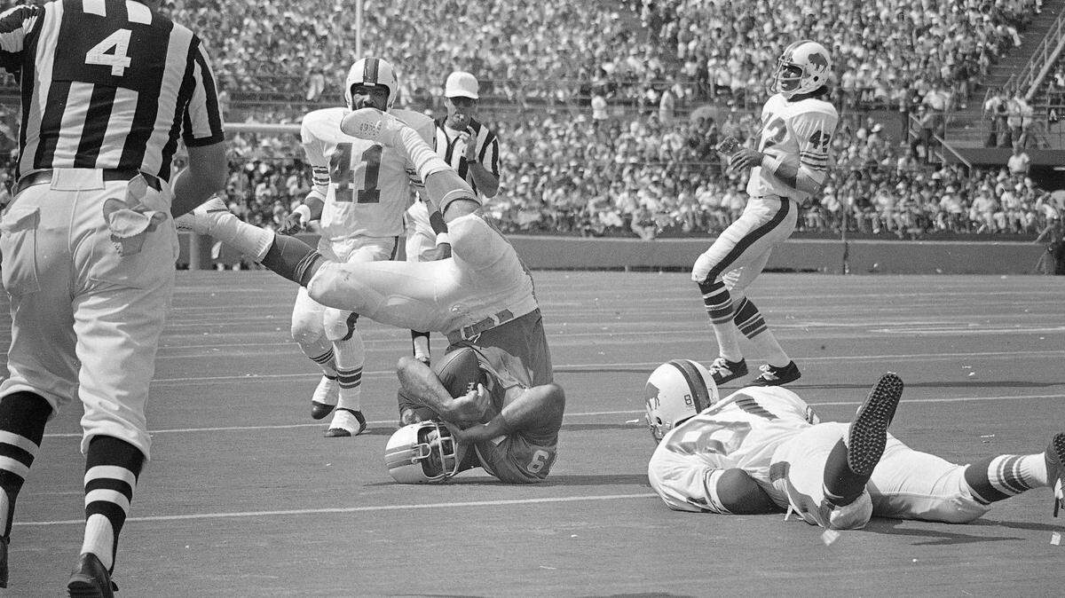 Larry Csonka (39) of the Miami Dolphins gets some neck strain as he makes 4-yards and a first down In Miami, Fla., Oct. 22, 1972 against the Buffalo Bills. (AP Photo)