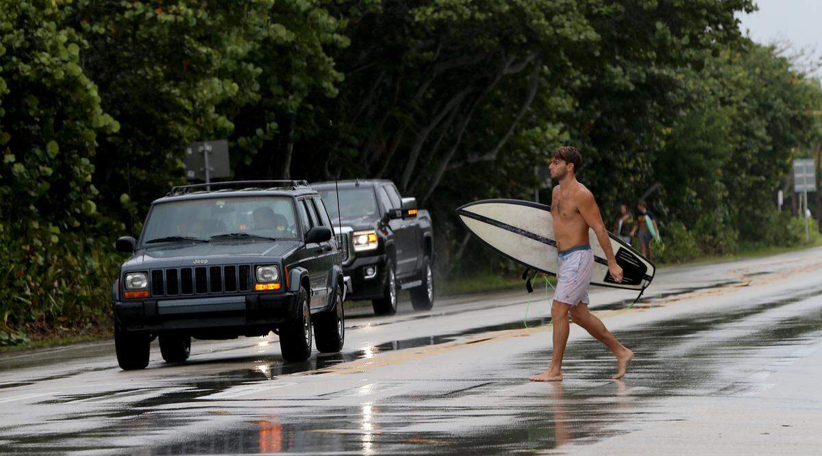 Surfers are known to line up ahead of hurricanes like Erin, like this one crossing A1A on his way to the Spanish River Park beach in Boca Raton as Hurricane Dorian neared in 2019.