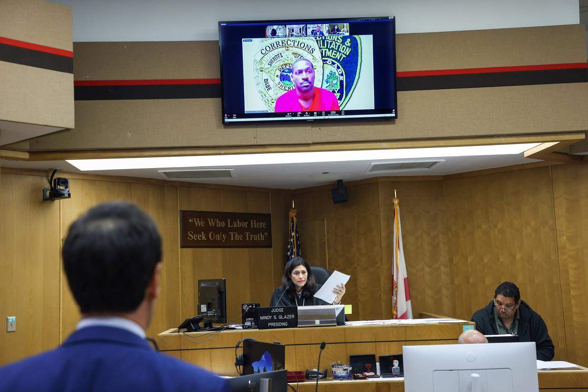 Antonio Brown, on the screen, appears for his bond hearing via Zoom requesting bail after his attorney, Mark Eiglarsh, right, filed a written plea of “not guilty” to the attempted murder charge in Bond Court (Courtroom 1-5) with Judge Mindy S. Glazer, center, presiding at the Richard E. Gerstein Justice Building on Wednesday, November 12, 2025, in Miami, Florida.