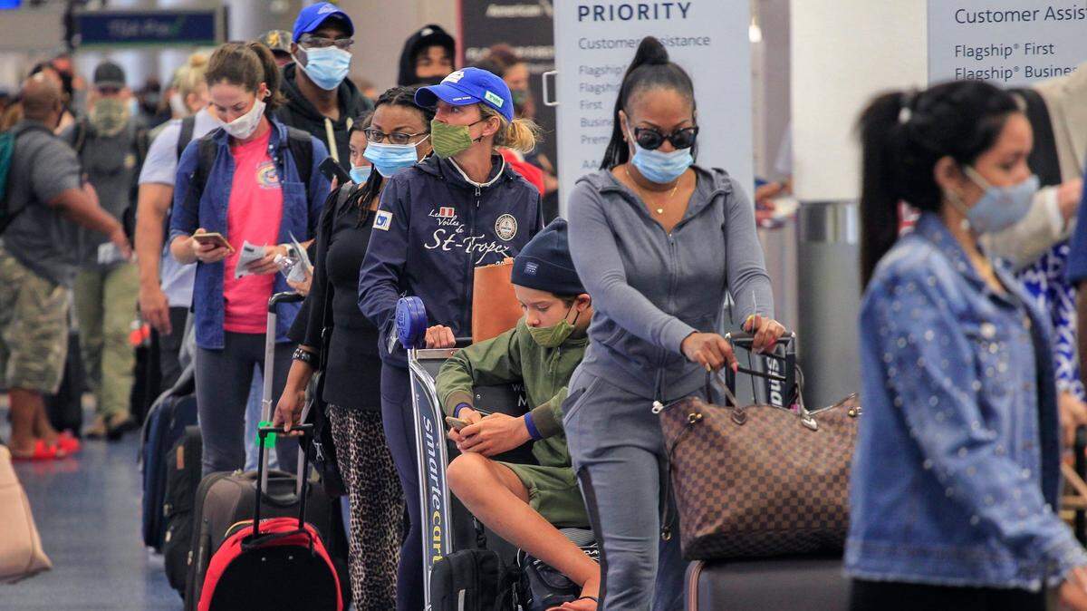 Miami International Airport reported a key benchmark with a monthly passenger uptick in November, the first since the pandemic started in March 2020. Here passengers are in line at the airport in April 2021.