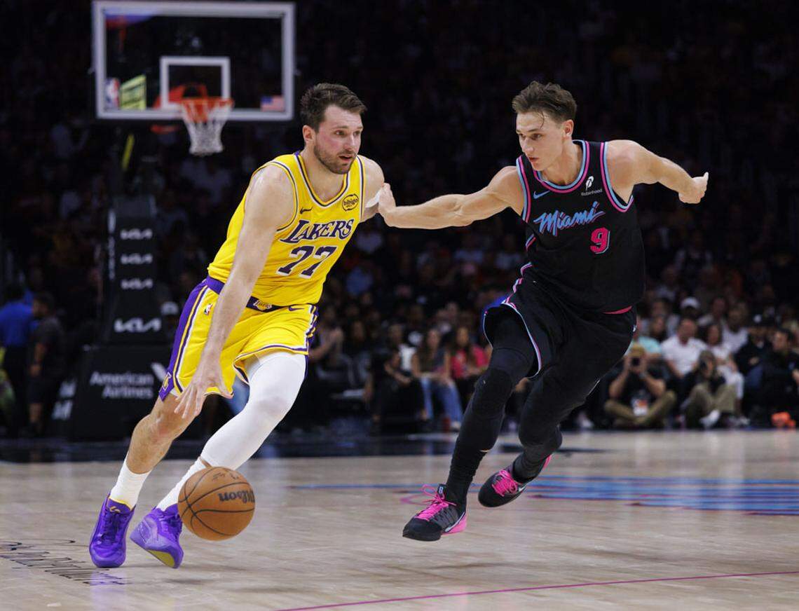 Los Angeles Lakers guard Luka Doncic (77) dribbles around Miami Heat guard Pelle Larsson (9) during the second half of a game on Thursday, March 19, 2026, at the Kaseya Center in downtown Miami, Fla. 