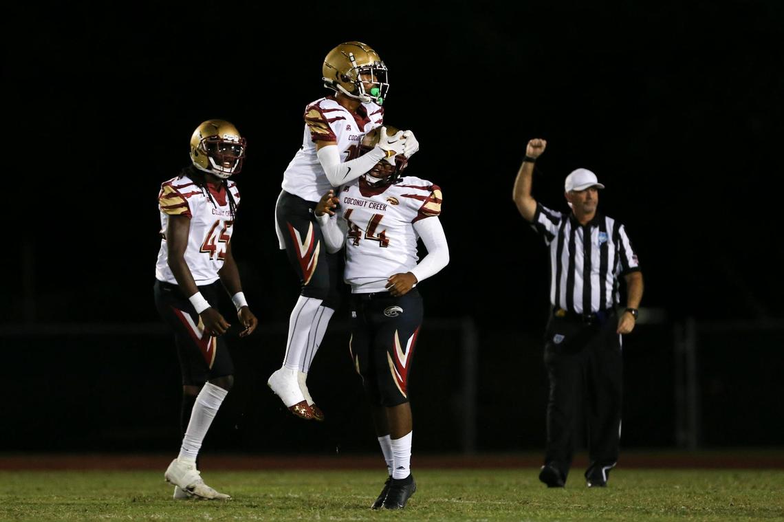 Coconut Creek Cougars defensive back Andre Poitier-Abreu (15) celebrates with defensive end Martin Montero jr (44) during the first quarter against the Palmetto Panthers at Miami Southridge Senior High School in South Miami, Florida, Thursday, November 3, 2022.