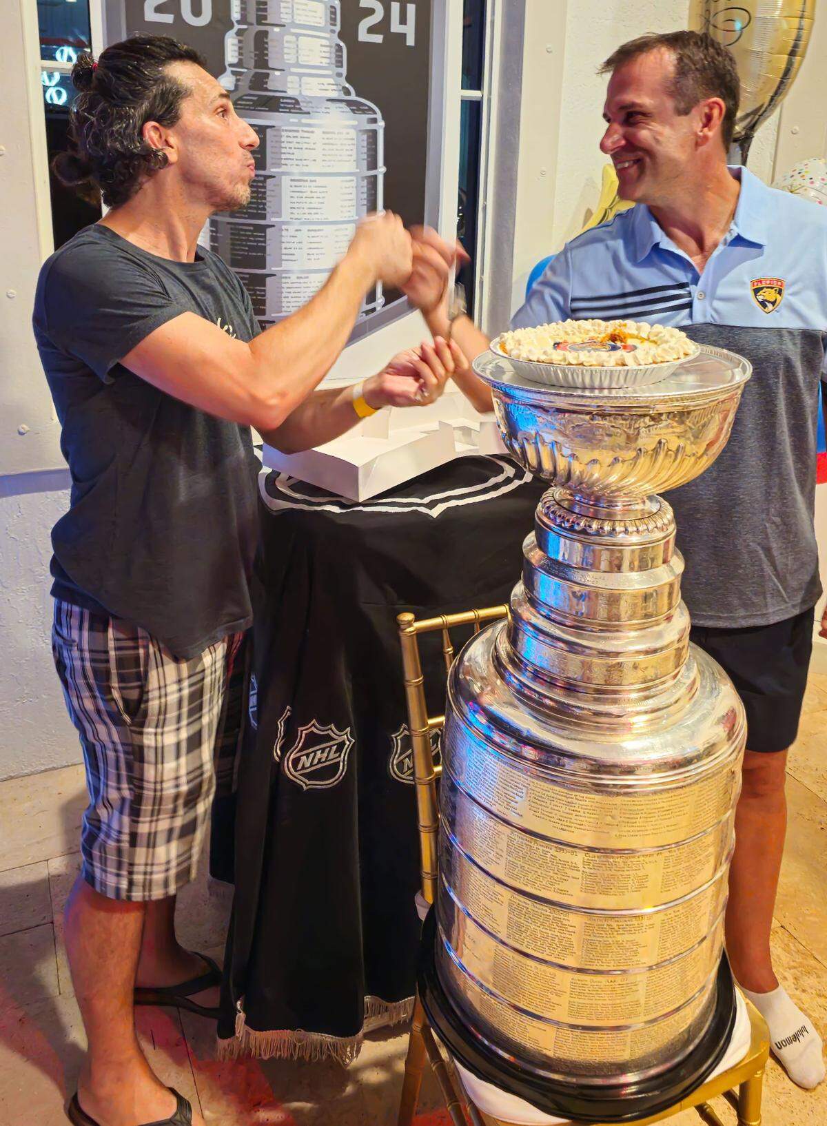 Joshua Abril of Fookem’s Fabulous with goaltender coach Robb Tallas of the Florida Panthers, who ate one of Abril’s famous Key lime pies out of the Stanley Cup.