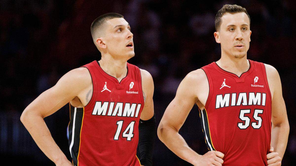 Miami Heat guard Tyler Herro (14) talks with forward Duncan Robinson (55) during the second half of a game against the Charlotte Hornets on March 10, 2025, at Kaseya Center in Miami.