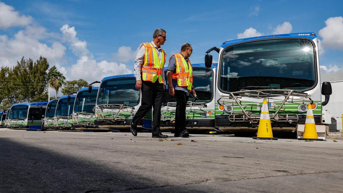 Felipe Hermida, Section Chief of Bus Operations, and Lazaro Dominguez, with the Department of Transportation and Public Works, seen left to right, walk past broken electric Proterra buses parked at Miami-Dade County Coral Way Bus Maintenance Facility in Miami on Wednesday, Feb. 19, 2025. The majority of the electric buses have not been able to be serviced since the bus company, Proterra, filed for bankruptcy.