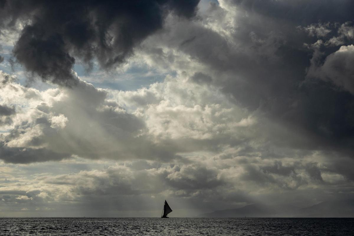 Isle de la Tortue, Haiti, March 26 2022 - A Haitian sail freighter makes it’s way along the Canal de la Tortue under threatening skies.