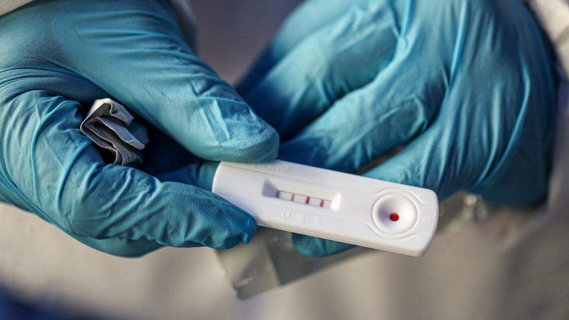 Health care worker Patricio Candia shows a rapid COVID-19 test with a positive result outside a supermarket in Santiago, Chile, on June 27, 2020. A study found rapid antigen COVID-19 tests were more effective than previously thought when compared to the standard PCR tests.