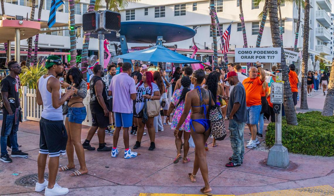 People walk down among members of the “God Squad” in front of the Clevelander Hotel, on Ocean Drive, during spring break, in Miami Beach, Florida. on Saturday March 22, 2025.