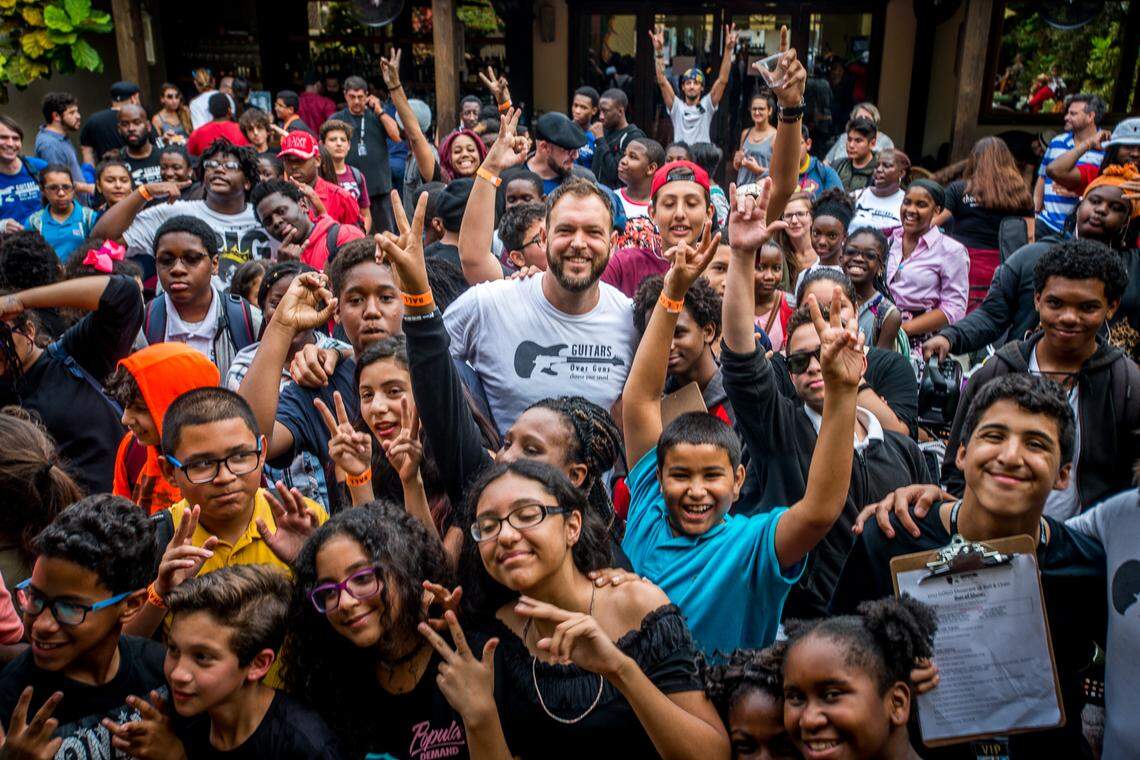 Guitars Over Guns CEO and founder Chad Bernstein, center, poses with students.