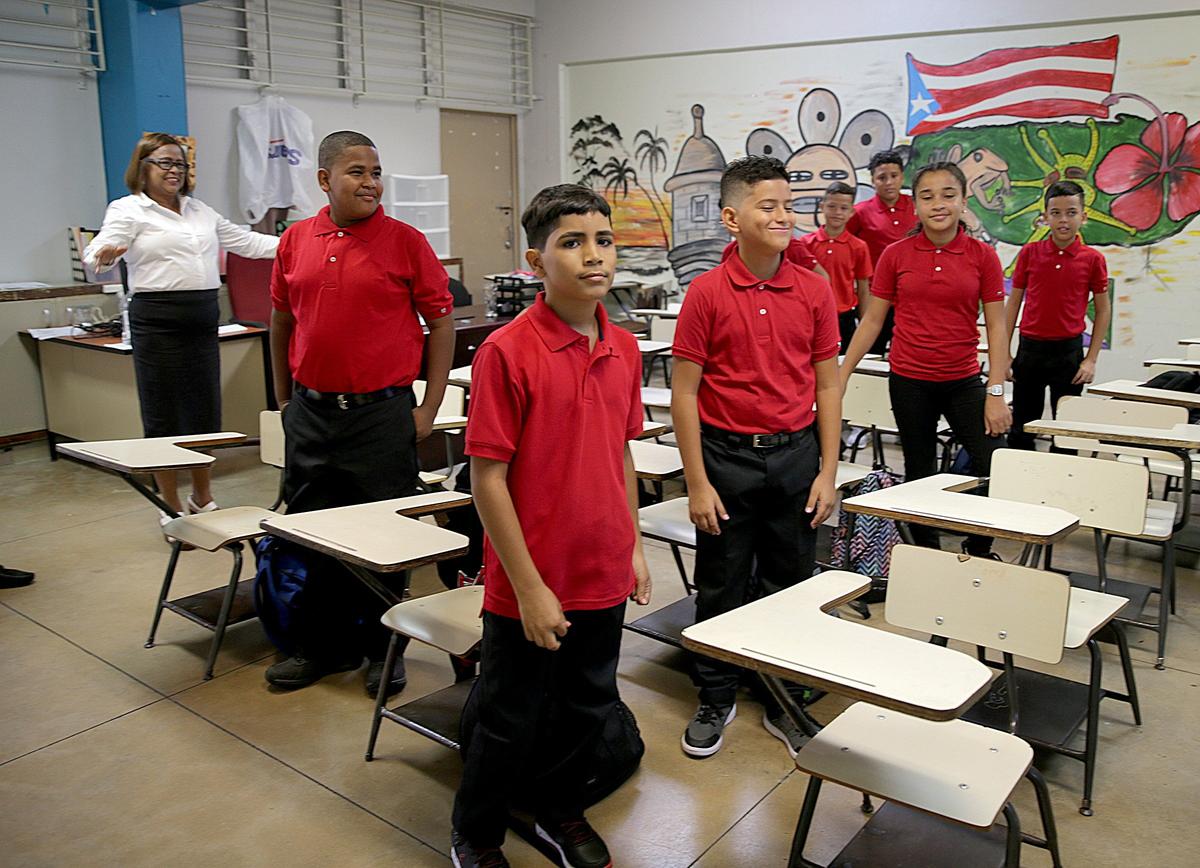 Principal Victoria Garcia Burgos welcomes sixth-grade students at Rosa Costa Valdivieso middle school on Monday, Aug. 13, 2018, the first day of classes of a new school year. Hurricane Maria devastated Puerto Rico almost a year ago.