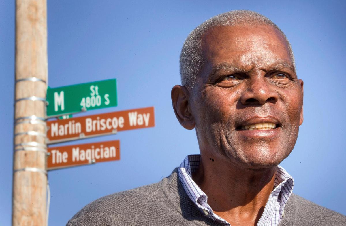 FILE - Marlin Briscoe stands in front of a street that was renamed for him in Omaha, Neb., on Oct. 22, 2014. Marlin Briscoe, the first Black starting quarterback in the American Football League, died Monday, June 27, 2022. His daughter, Angela Marriott, told The Associated Press that Briscoe, 76, died of pneumonia at a hospital in Norwalk, California. (Kent Sievers/Omaha World-Herald via AP, File)