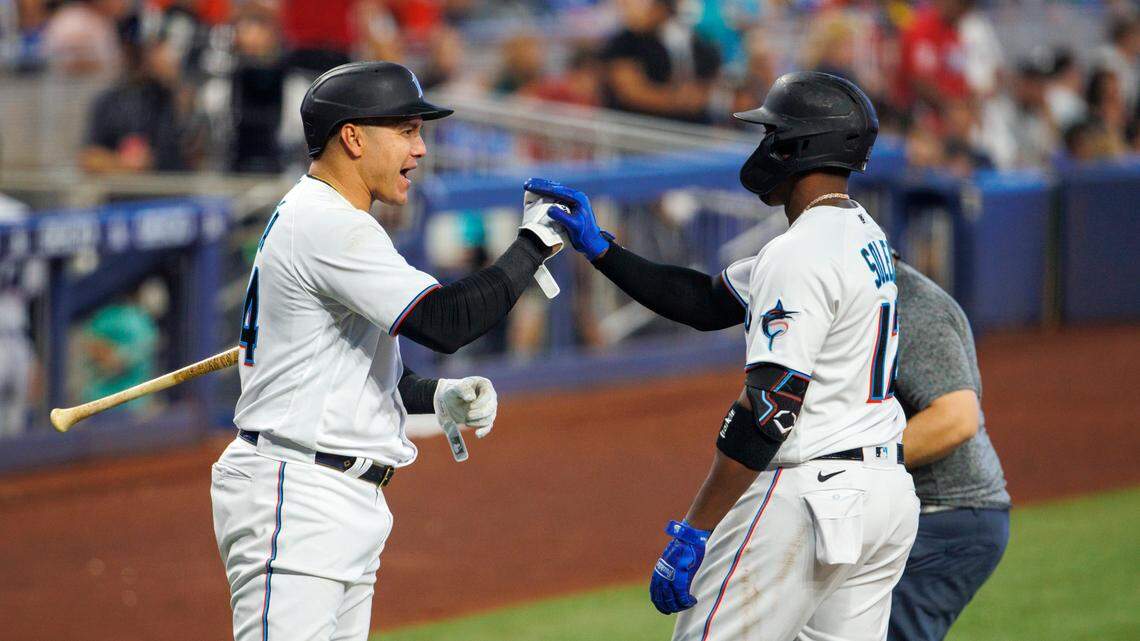 Miami Marlins left fielder Jorge Soler (12) is congratulated by designated hitter Avisail Garcia (24) after hitting a solo home run during the third inning of a baseball game against the Milwaukee Brewers at LoanDepot Park on Sunday, May 15, 2022 in Miami, Florida.