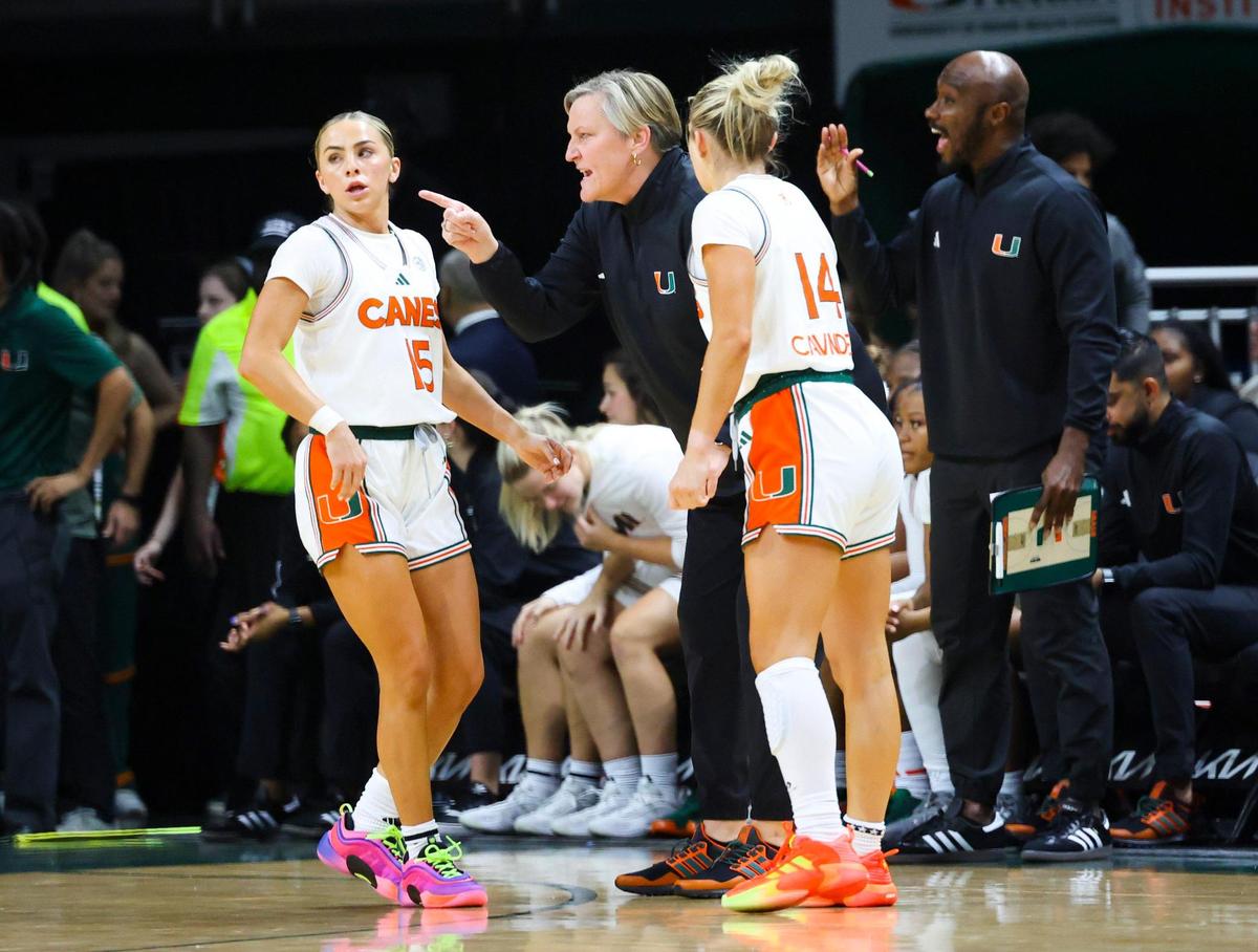 Miami Hurricanes Head Coach Tricia Cullop talks to Miami Hurricanes Hanna Cavinder(15) and Haley Cavinder(14) during the second quarter of a game on Tuesday, Nov. 19, 2024, at Watsco Center in Coral Gables, Fla.