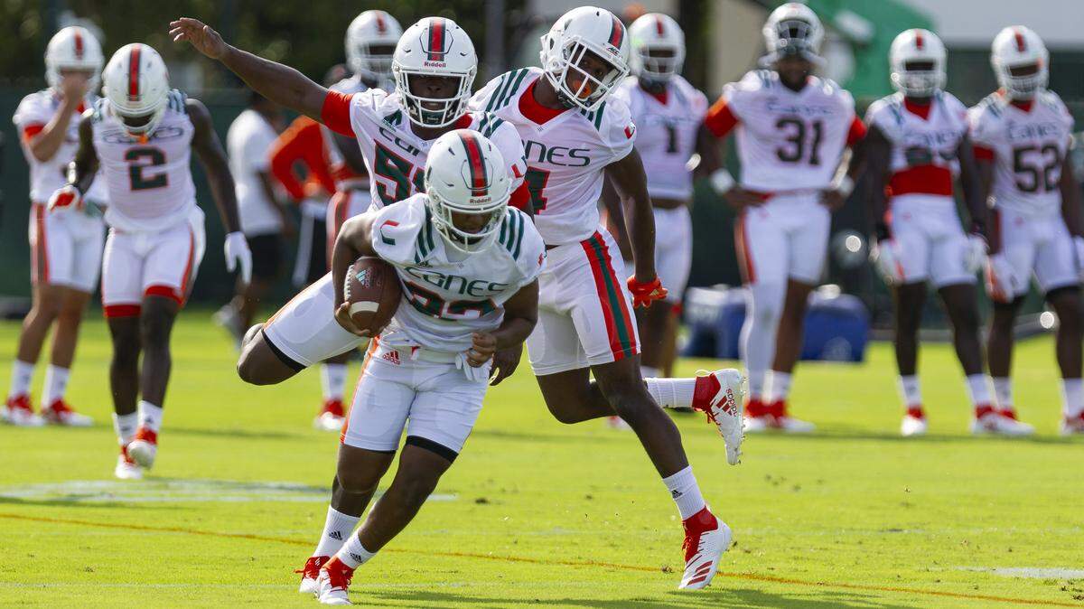 University of Miami linebacker Shaquille Quarterman (55) and safety Jaquan Johnson (4) chase after defensive back Tyler Murphy (32) during the first day of fall training camp at the Greentree Practice Fields in Coral Gables on Saturday, August 4, 2018.