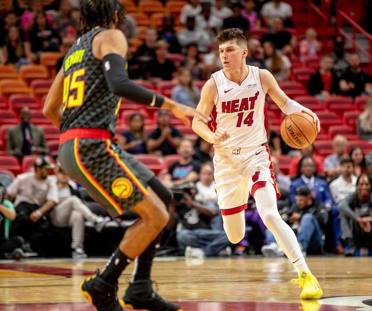 Heat guard Tyler Herro (14) dribbles the ball down court while being defended by Hawks forward DeAndre’ Bembry (95) during the first quarter of a basketball game against Atlanta at AmericanAirlines Arena on Oct. 14, 2019.