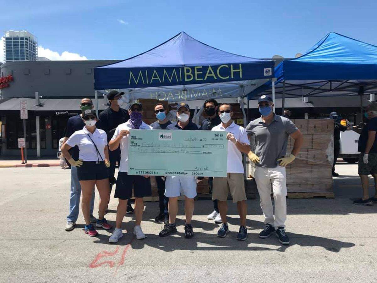 Miami Beach Commissioner Ricky Arriola presents a $5,000 donation from his company, Inktel, to Feeding South Florida on Wednesday. Arriola announced he would donate $17,000 of his salary to South Florida Seniors in Action.