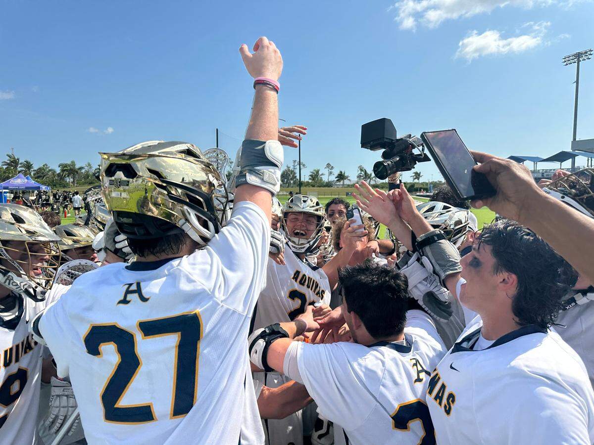 Aquinas senior Ben Kupstas celebrates with the rest of his teammates after the Raiders’ boys’ lacrosse team beat Tampa Plant on Thursday in a Class 2A state semifinal in Naples, Fla.