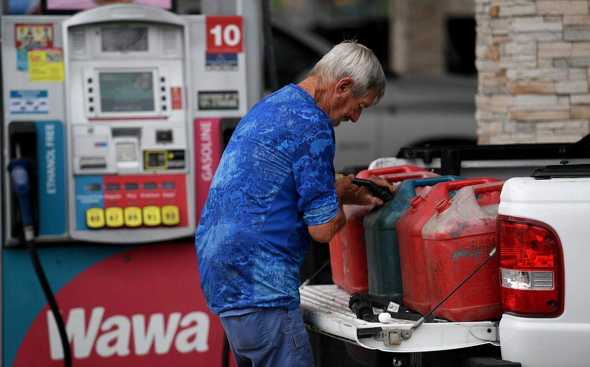 A man fills several gas tanks in the back of his truck at the Wawa station on First Street in Bradenton on May 12, 2021. Several gas stations in town have run out of gas, but local officials say there’s plenty of fuel arriving at Port Manatee. 
