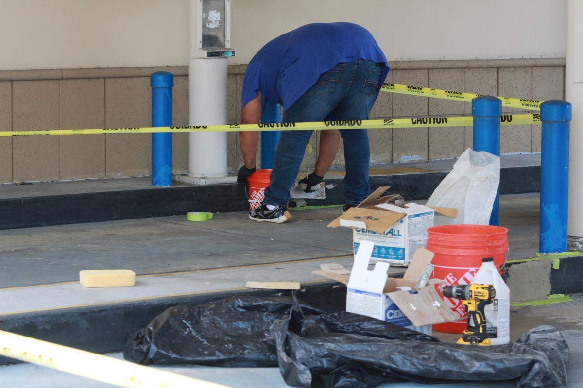 A worker fixes the damages of a shooting at a West Kendall Chase Bank that was the scene of a murder-suicide that left two adults dead and a child.