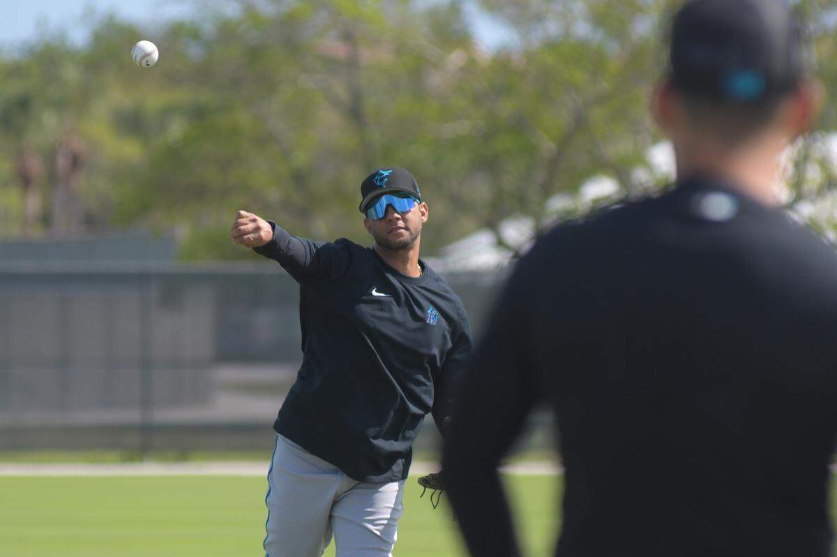 Miami Marlins first baseman Yuli Gurriel throws to shortstop Jose Iglesias during a workout on the back fields of the Roger Dean Chevrolet Stadium complex on Friday, March 10, 2023, in Jupiter, Florida.