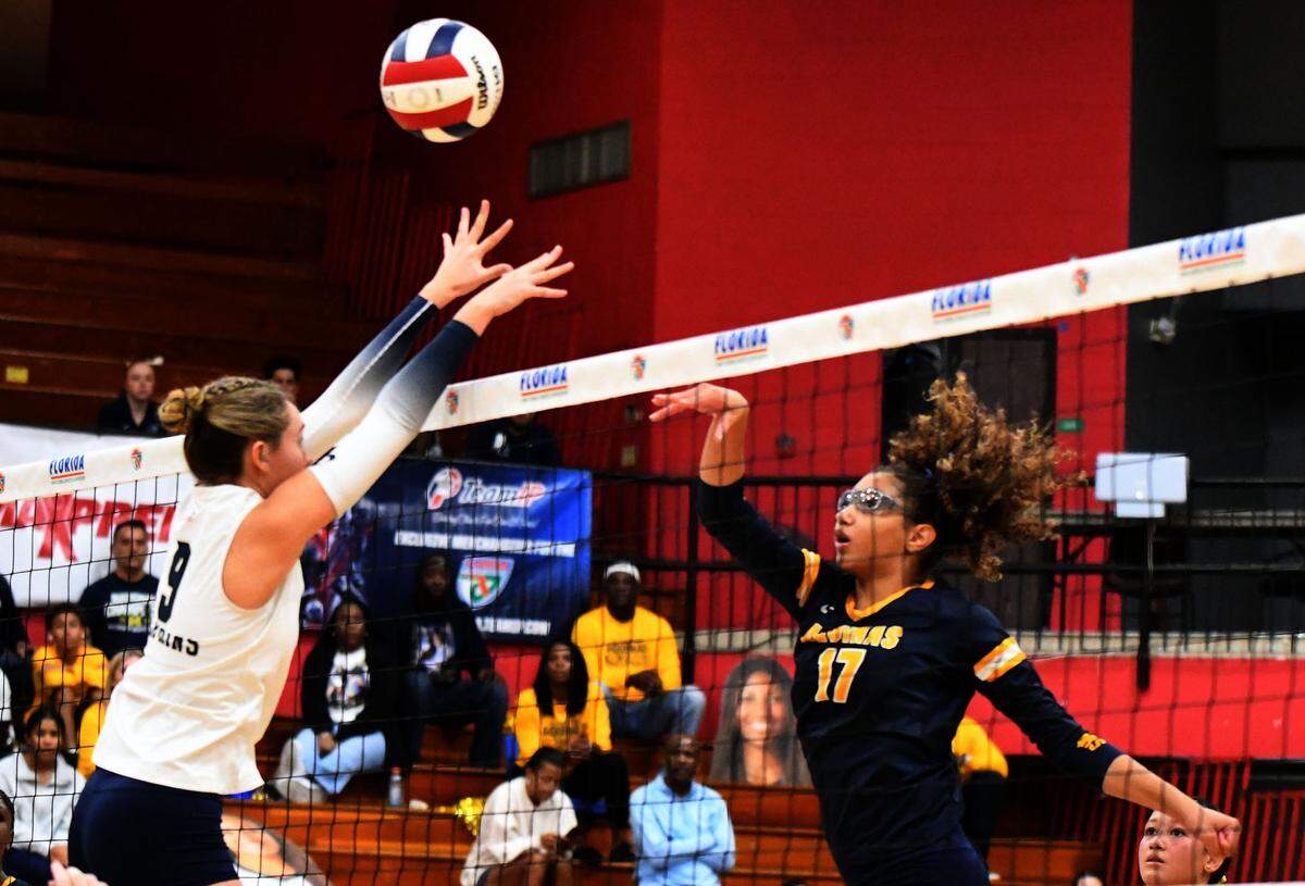 St. Thomas Aquinas junior Sydney Guerrier pushes a shot over the net against Gulf Breeze during the Class 6A girls volleyball state championship game on Saturday at Polk State College in Winter Haven, Fla.