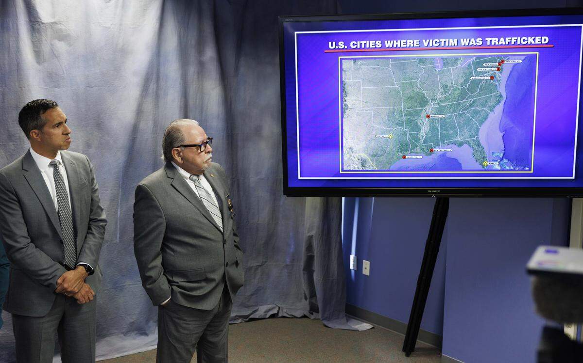Jose Figueredo, Homeland Security Investigations Special Agent in Charge, left, and Emiliano Tamayo, Chief of Investigations, look at a map depicting where in the country the victim was trafficked during a press conference discussing charges in a human trafficking case on Tuesday, Nov. 25, 2025, at Miami-Dade State Attorney's Office in Miami, Fla.