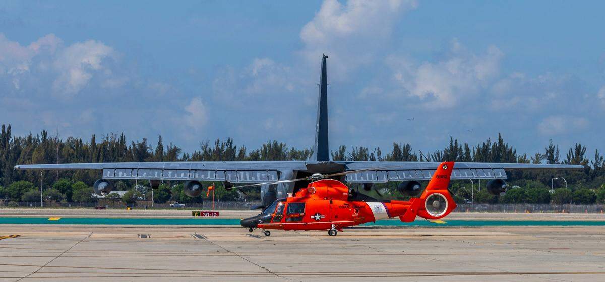 A U.S. Coast Guard HH-65C Dolphin helicopter taxis behind a military aircraft at Coast Guard Air Station Opa-locka on Friday, May 23, 2025, ahead of the Hyundai Air & Sea Show’s return to Miami Beach for the annual National Salute to America’s Heroes.