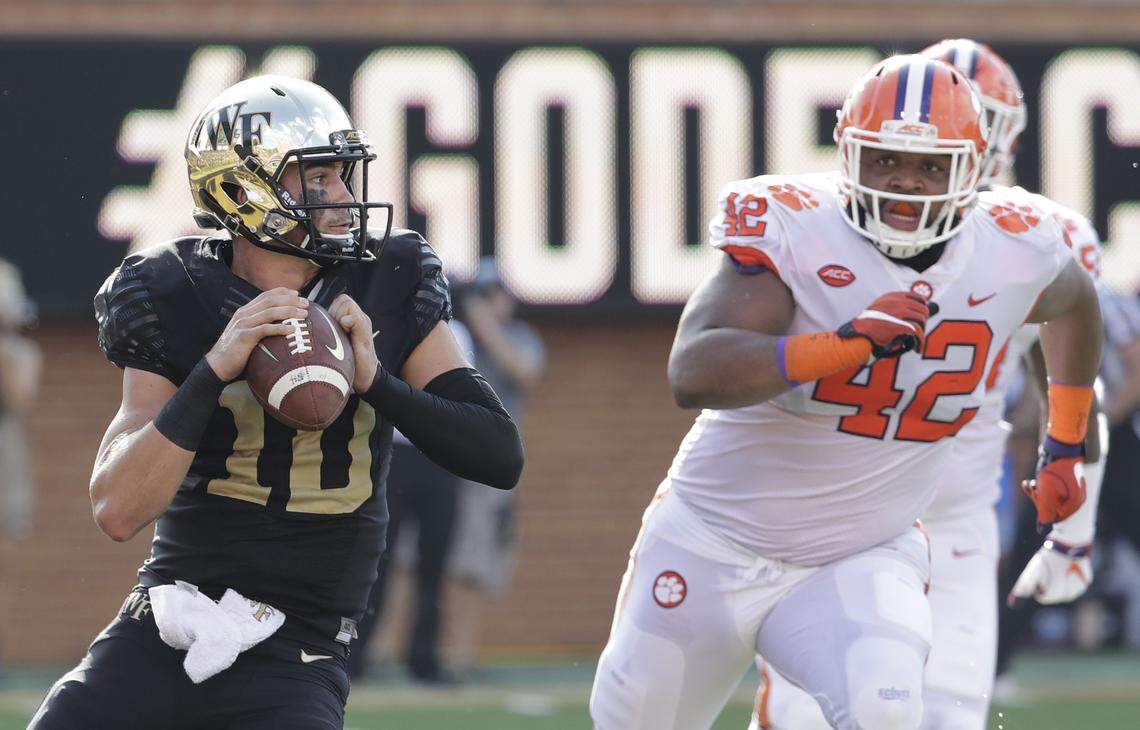Wake Forest’s Sam Hartman (10) looking to pass under pressure from Clemson’s Christian Wilkins (42) during the first half of an NCAA college football game in Charlotte, N.C. Wilkins is here to put a smile on your face, whether you like it or not. For four seasons, Wilkins has been bringing the jokes, zingers and sneaky pinches on the bottom at Clemson. The 300-pound All-America defensive tackle famously celebrated the Tigers’ 2016 national championship with a split and flashed a Heisman pose after a touchdown run this season.