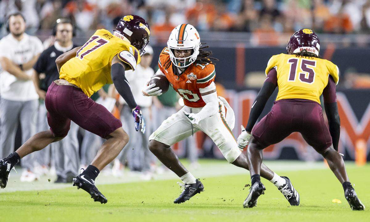 Miami Hurricanes wide receiver Malachi Toney (10) runs with the ball as Bethune-Cookman Wildcats safety Antwone Watts (15) and cornerback Gabe White (17) defend in the first half of their NCAA football game at Hard Rock Stadium on Saturday, Sept. 6, 2025, in Miami Gardens, Fla.