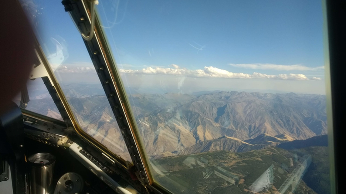 A thin layer of cumulus clouds caps dense smoke from the Kiawah-Rabbit Foot fires in eastern Idaho during August 2018, as viewed from a C-130 research plane.
