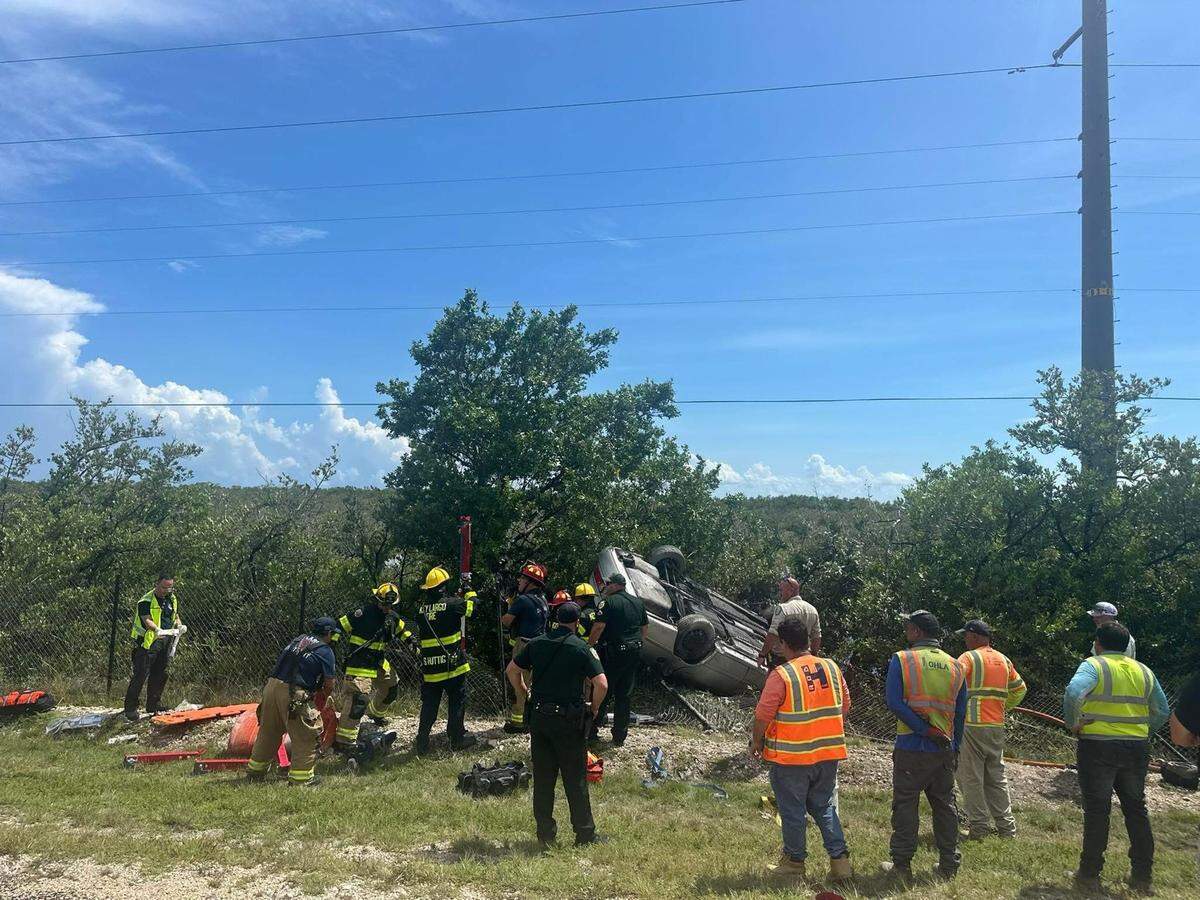 First responders work to free a woman who was trapped in her overturned car after it crashed off the side of the 18 Mile Stretch of U.S. 1 in Key Largo Wednesday, Aug. 20, 2025.